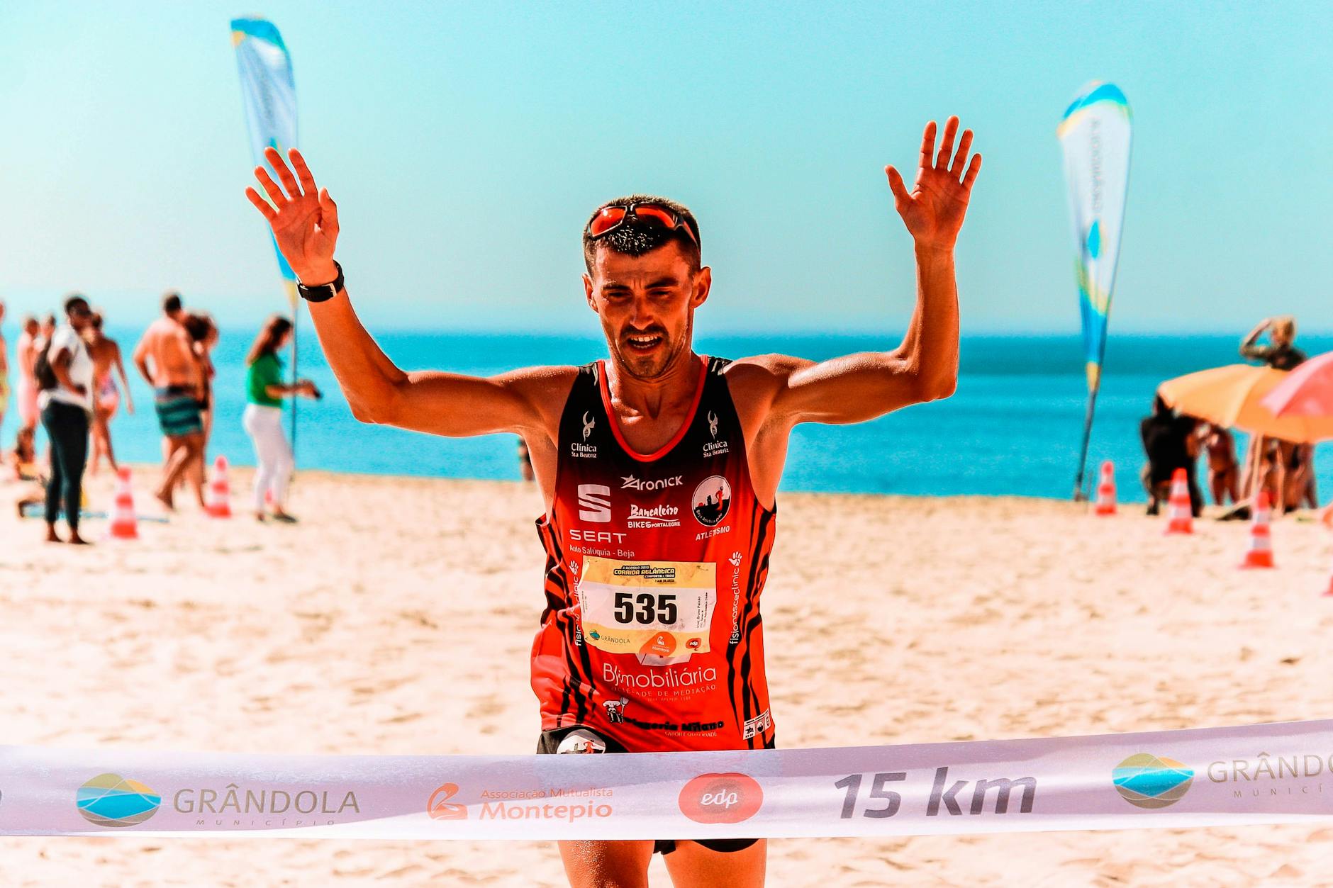 Triathlonista świętuje zwycięstwo na słonecznej plaży w Portugalii